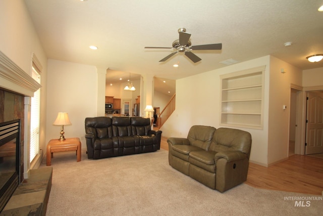1491 N Millstream Ct, Nampa, ID 83686 - carpeted living area with a tile fireplace, decorative columns, stairs, a ceiling fan, and built in features