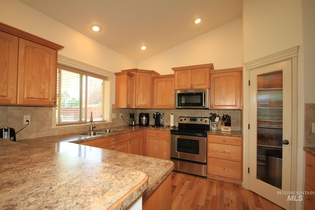 1491 N Millstream Ct, Nampa, ID 83686 - kitchen with appliances with stainless steel finishes, lofted ceiling, recessed lighting, decorative backsplash, and light wood-style floors