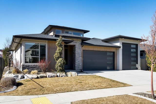 prairie-style house with a garage, stone siding, and concrete driveway