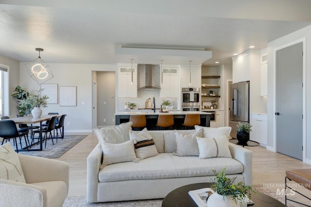 living room featuring light wood-style floors, baseboards, and recessed lighting