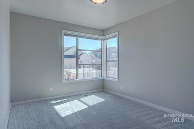 empty room with baseboards and carpet flooring