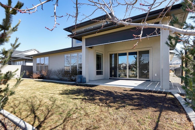 back of house featuring a patio, a yard, fence, and stucco siding