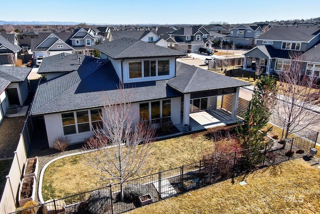 exterior space featuring a shingled roof, a residential view, and a fenced backyard