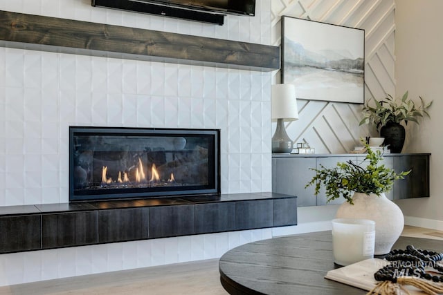 room details with wood finished floors and a glass covered fireplace