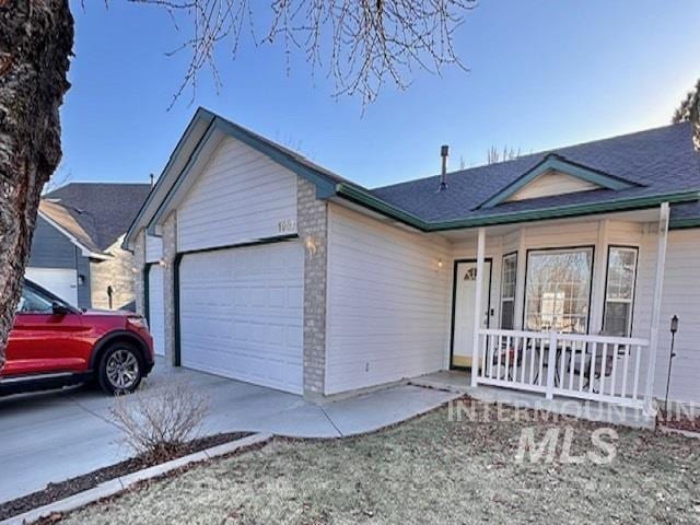 single story home featuring a porch and a garage