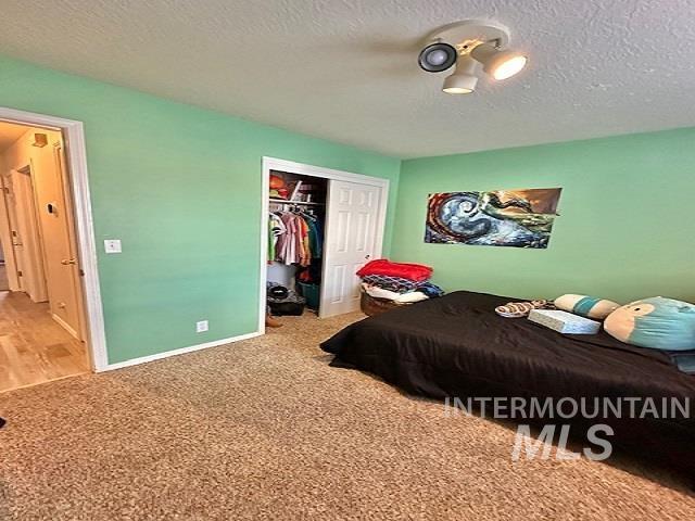 carpeted bedroom featuring a closet and a textured ceiling