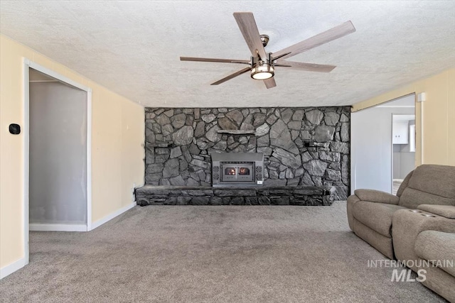 living room with carpet flooring, ceiling fan, a textured ceiling, and a fireplace