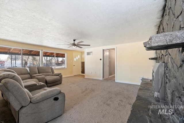 living room with dark colored carpet, a stone fireplace, ceiling fan, and a textured ceiling