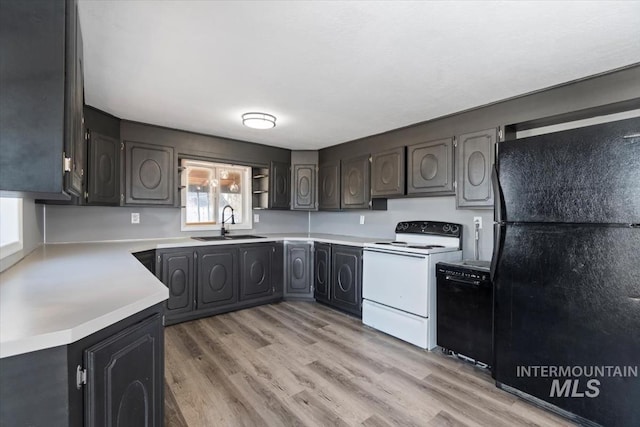 kitchen with white electric range, sink, light wood-type flooring, and black fridge