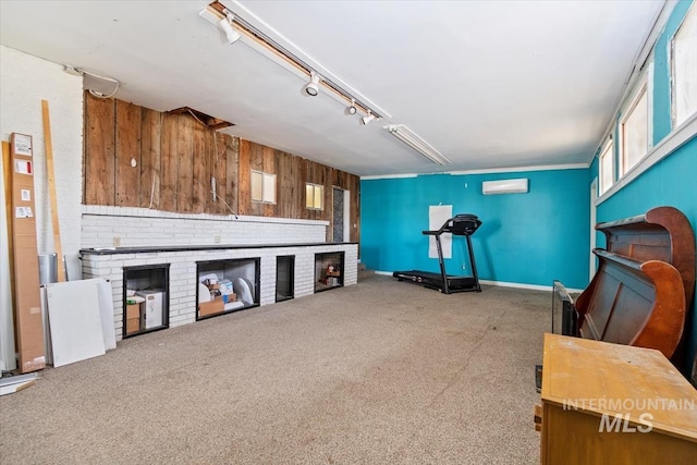 interior space with a wall mounted air conditioner, wooden walls, a fireplace, and carpet