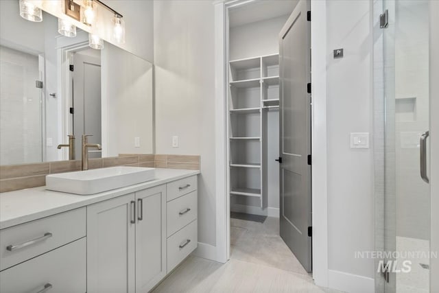 8469 W Happy Day Dr, Meridian, ID 83646 - bathroom featuring a shower stall, a spacious closet, vanity, and baseboards