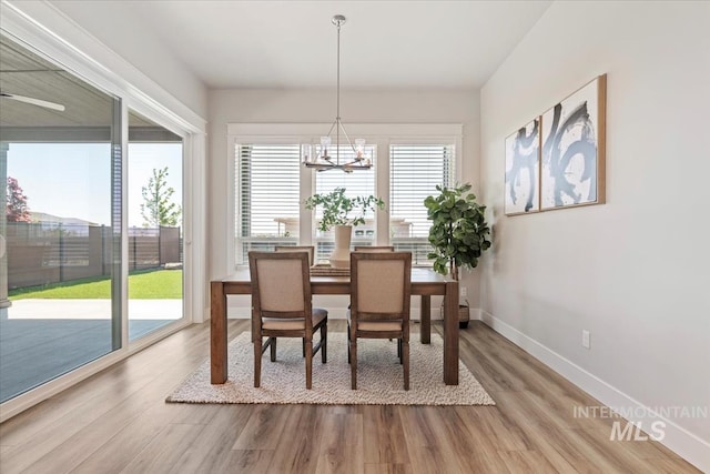 8469 W Happy Day Dr, Meridian, ID 83646 - dining area featuring wood finished floors, a chandelier, and baseboards