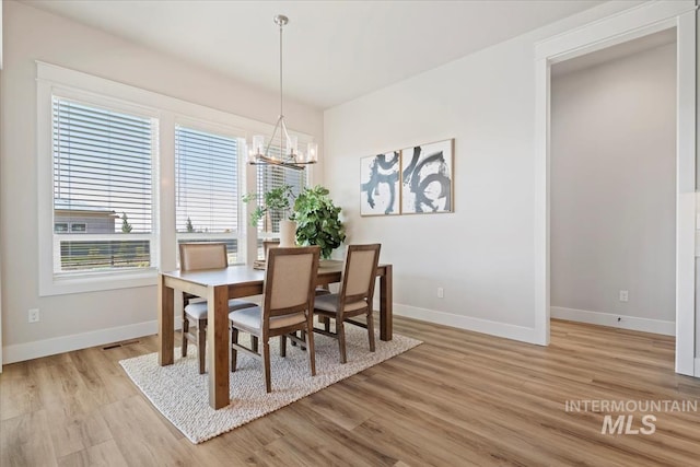 8469 W Happy Day Dr, Meridian, ID 83646 - dining room with a chandelier, plenty of natural light, light wood finished floors, and baseboards