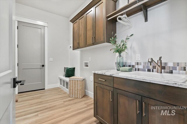 8469 W Happy Day Dr, Meridian, ID 83646 - laundry room with hookup for a washing machine, cabinet space, baseboards, and light wood-type flooring