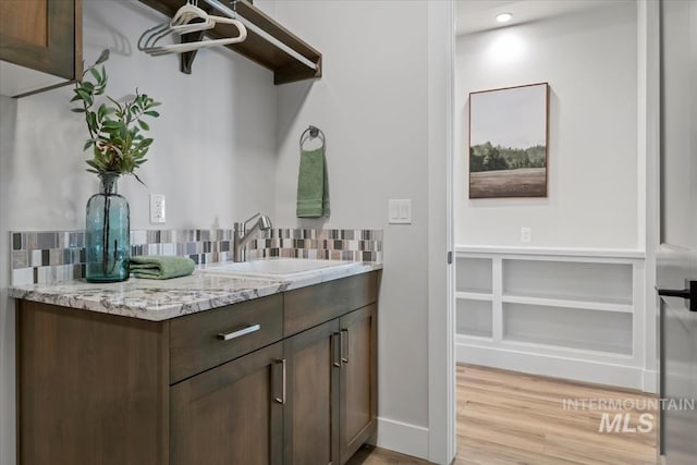 8469 W Happy Day Dr, Meridian, ID 83646 - bathroom with backsplash, vanity, baseboards, and wood finished floors