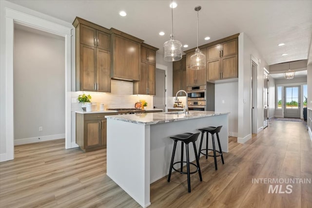 8469 W Happy Day Dr, Meridian, ID 83646 - kitchen featuring a sink, baseboards, recessed lighting, decorative backsplash, and light wood-style flooring