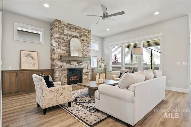 8469 W Happy Day Dr, Meridian, ID 83646 - living area featuring a fireplace, light wood-style floors, ceiling fan, recessed lighting, and baseboards
