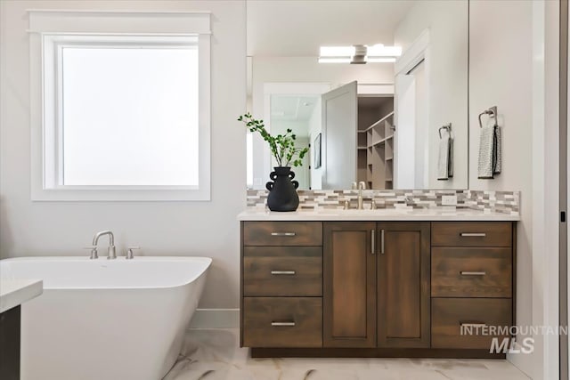 8469 W Happy Day Dr, Meridian, ID 83646 - bathroom featuring decorative backsplash, vanity, marble finish flooring, and a soaking tub