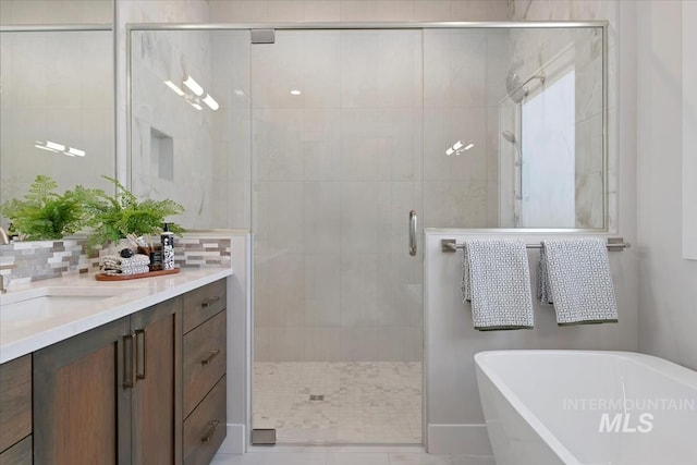 8469 W Happy Day Dr, Meridian, ID 83646 - bathroom featuring a soaking tub, vanity, a stall shower, tasteful backsplash, and tile patterned floors