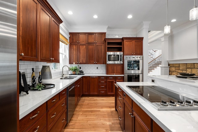 876 E Pennsylvania Ln, Boise, ID 83706 - kitchen with a sink, built in appliances, decorative light fixtures, crown molding, and light wood finished floors