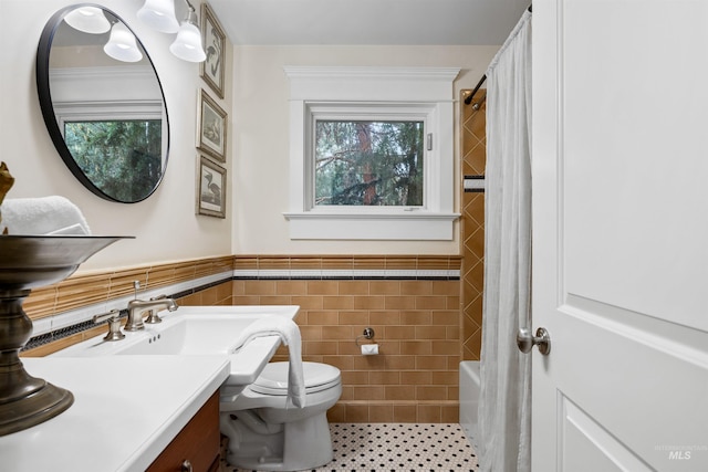 876 E Pennsylvania Ln, Boise, ID 83706 - bathroom with tile walls, toilet, plenty of natural light, vanity, and a wainscoted wall