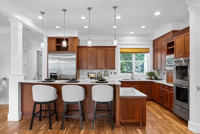 876 E Pennsylvania Ln, Boise, ID 83706 - kitchen featuring appliances with stainless steel finishes, open shelves, a sink, ornate columns, and light countertops