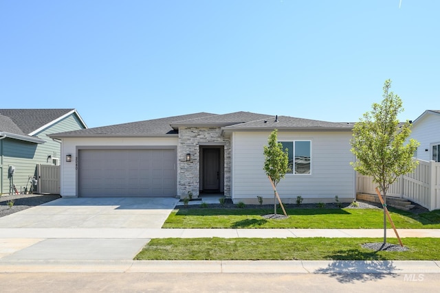 view of front of home featuring driveway, an attached garage, fence, and a front yard