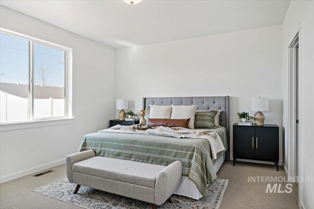 carpeted bedroom with multiple windows, visible vents, and baseboards