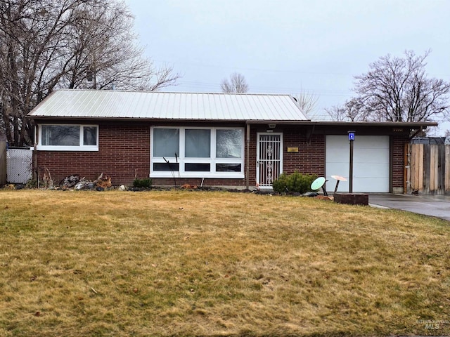 single story home with a front lawn, an attached garage, and brick siding