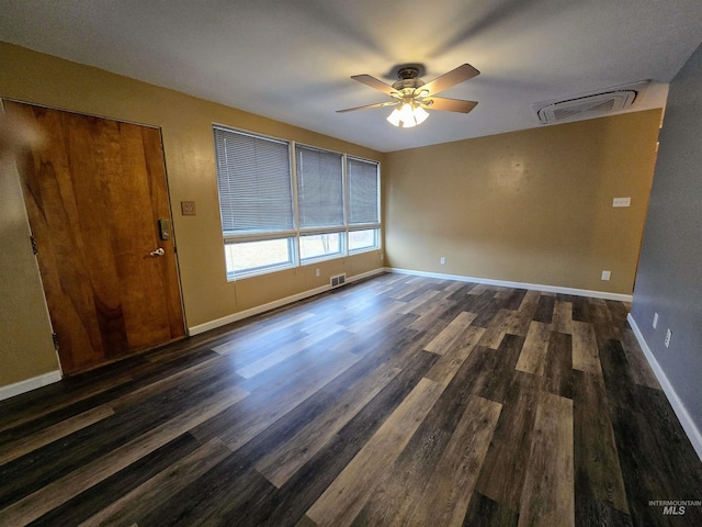 spare room featuring wood finished floors, visible vents, and baseboards