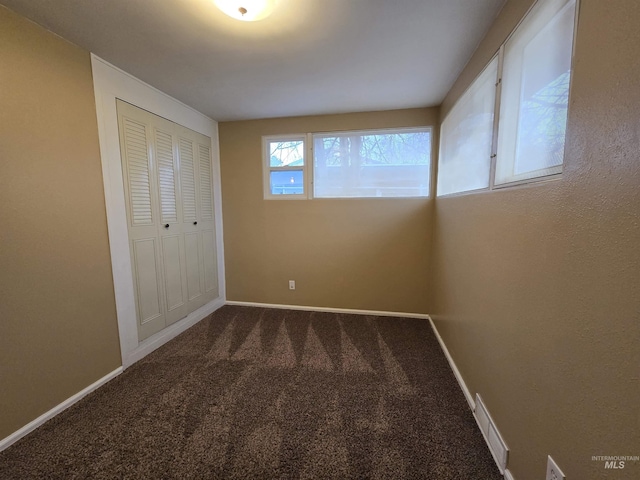 unfurnished bedroom with a closet, carpet flooring, and baseboards