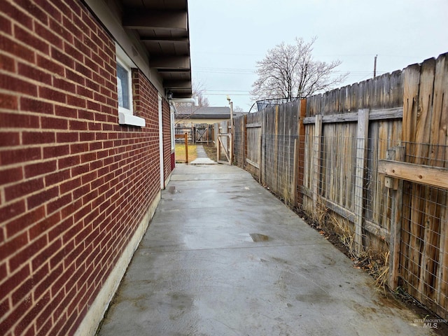 view of side of property featuring brick siding and fence