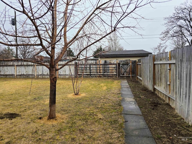 view of yard with a fenced backyard and a gate