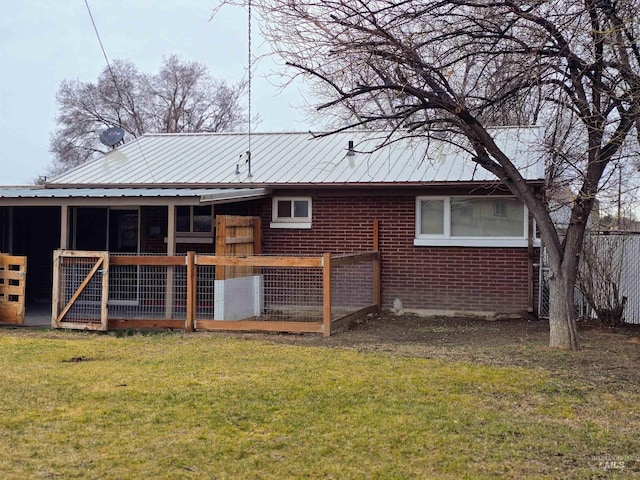 back of house with brick siding and metal roof