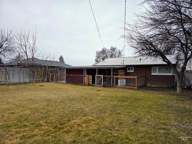 rear view of house with an exterior structure, metal roof, brick siding, and an outdoor structure