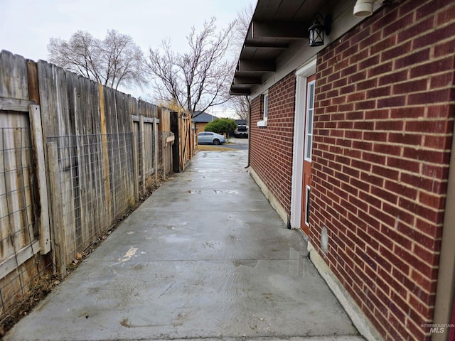 view of side of property with fence and brick siding