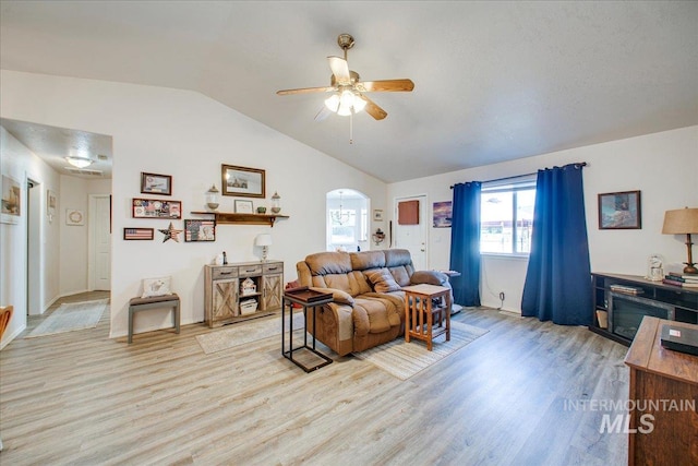 living room with ceiling fan, light hardwood / wood-style flooring, and vaulted ceiling