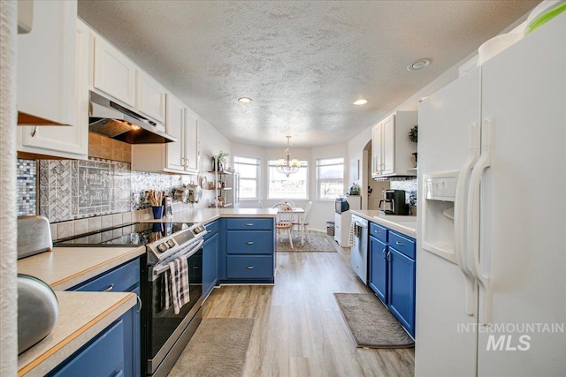 kitchen featuring light hardwood / wood-style flooring, stainless steel appliances, hanging light fixtures, and white cabinetry