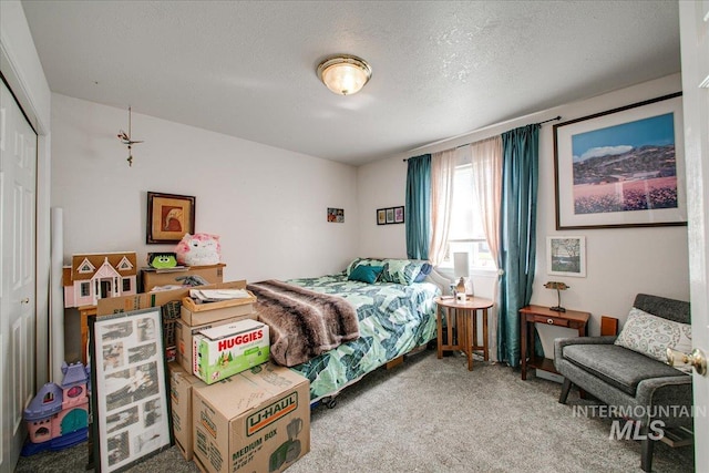 carpeted bedroom with a closet and a textured ceiling