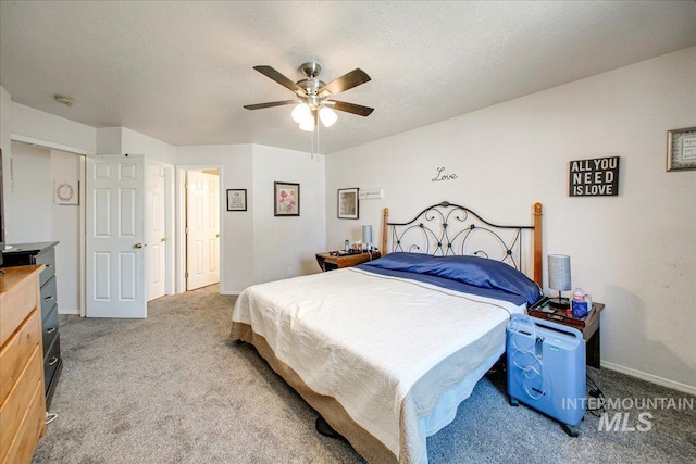 bedroom featuring a textured ceiling, light carpet, and ceiling fan