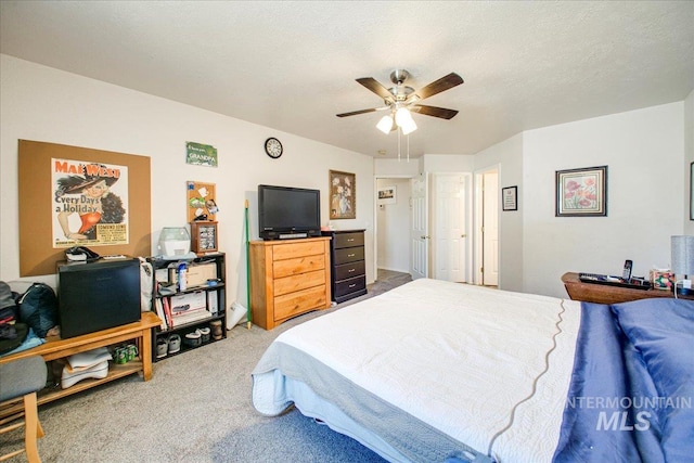 bedroom featuring a textured ceiling, carpet flooring, and ceiling fan