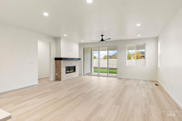 unfurnished living room featuring light wood-style floors, a fireplace, a ceiling fan, and recessed lighting
