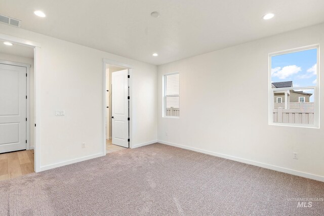 unfurnished room featuring visible vents, baseboards, recessed lighting, and light colored carpet