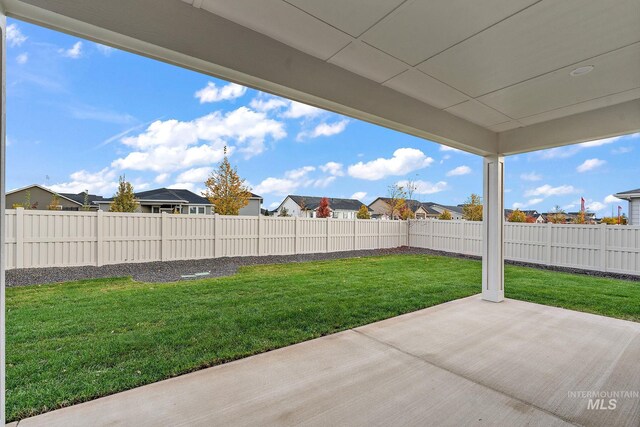 view of yard with a fenced backyard, a residential view, and a patio