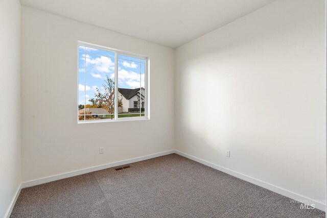 empty room with baseboards, carpet, and visible vents