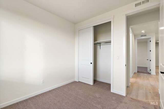 unfurnished bedroom featuring a closet, visible vents, and baseboards
