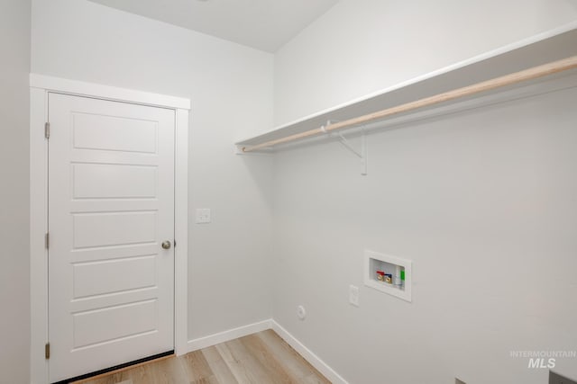 laundry room featuring washer hookup and light hardwood / wood-style flooring