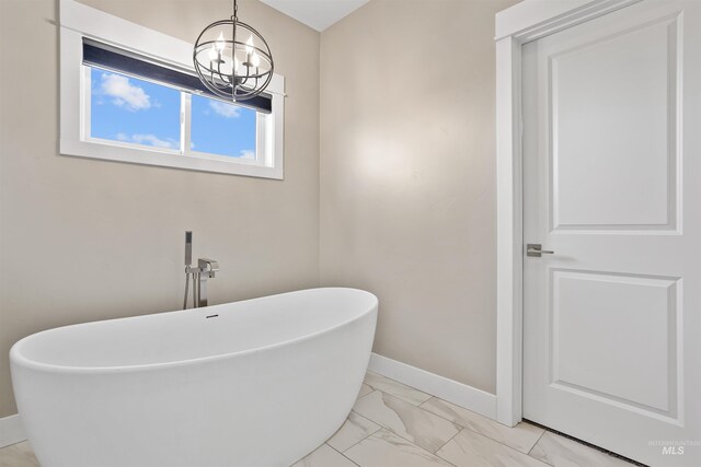 129 E 33 S, Burley, ID 83318 - bathroom with marble finish floor, baseboards, a freestanding bath, and an inviting chandelier