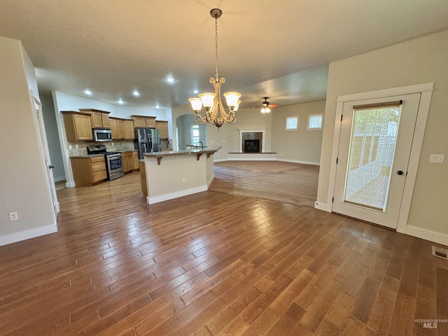 2577 Longbow Dr, Twin Falls, ID 83301 - kitchen featuring stainless steel appliances, open floor plan, a chandelier, a breakfast bar area, and wood finished floors
