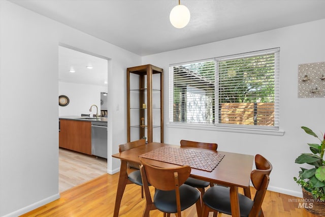 dining room with light wood-type flooring and baseboards